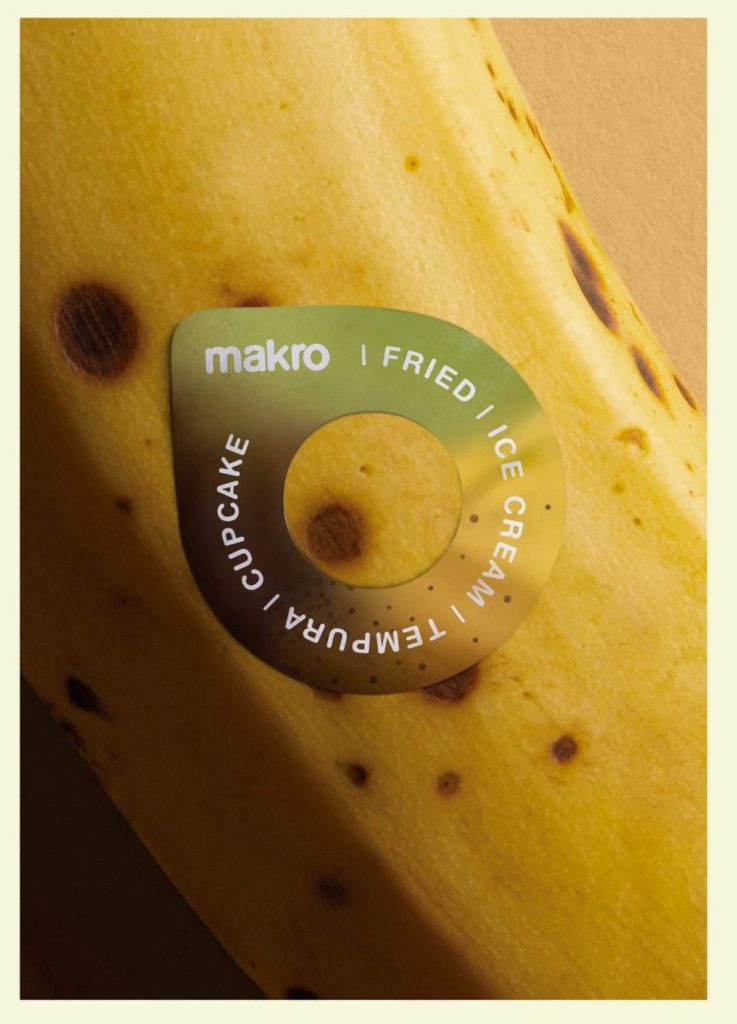 Foto de un plátano con la etiqueta salvavidas de la cadena de supermercados Makro. La etiqueta es un anillo que muestra los diferentes colores del plátano según su estado de maduración (del verde al marrón) e indica el mejor método de preparación según éste.